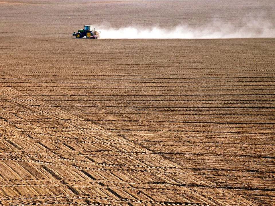 Tractor ploughing a large agricultural field
